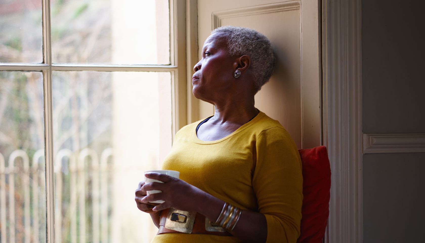 Senior woman looking thoughtfully out window