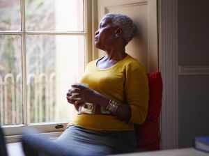 Senior woman looking thoughtfully out window