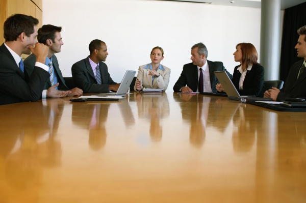 Group of business people at conference table, businesswoman at centre