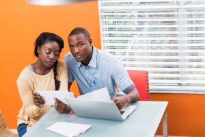 Young black couple paying bills at home