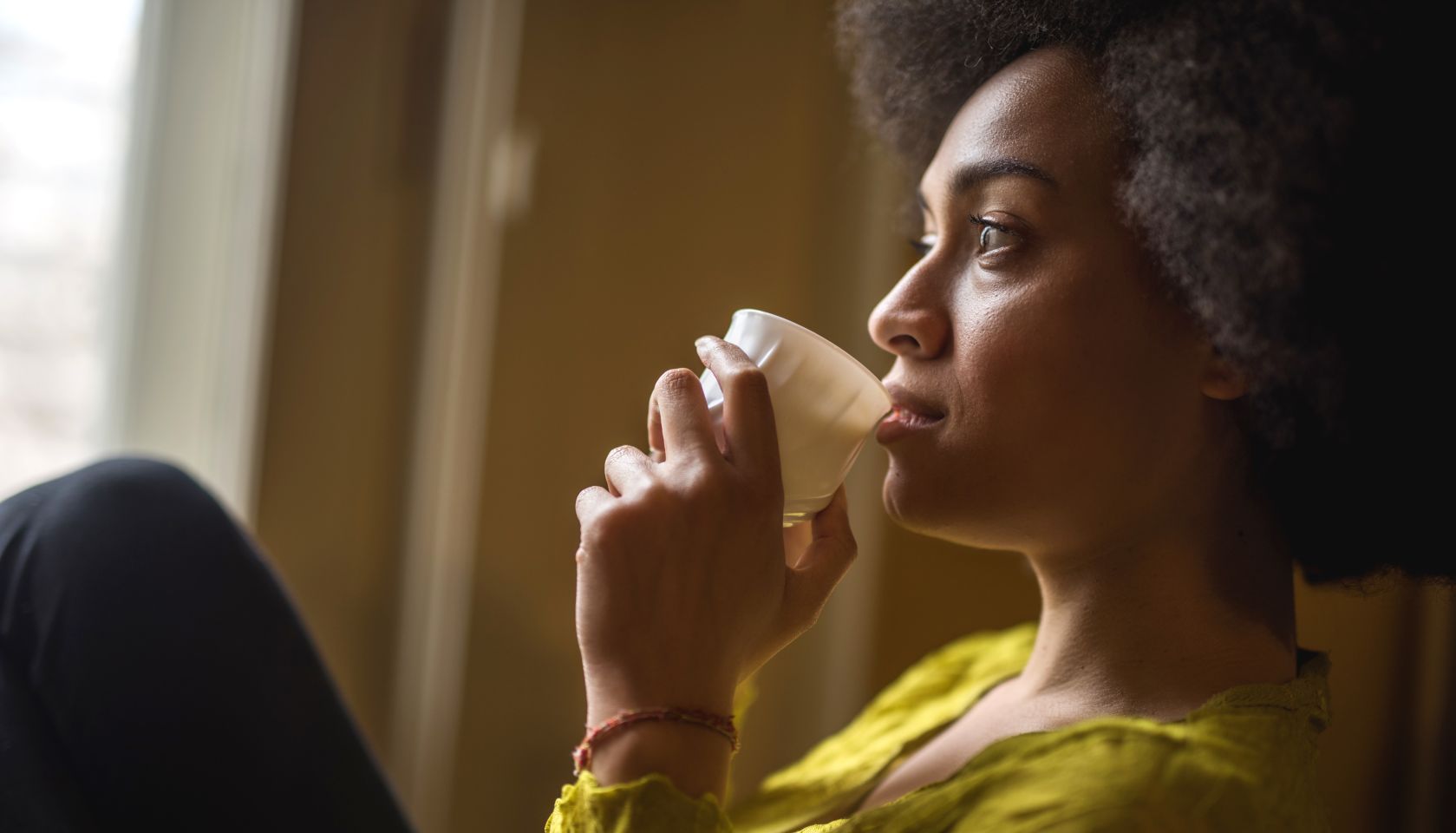Close up of pensive African American woman drinking coffee.