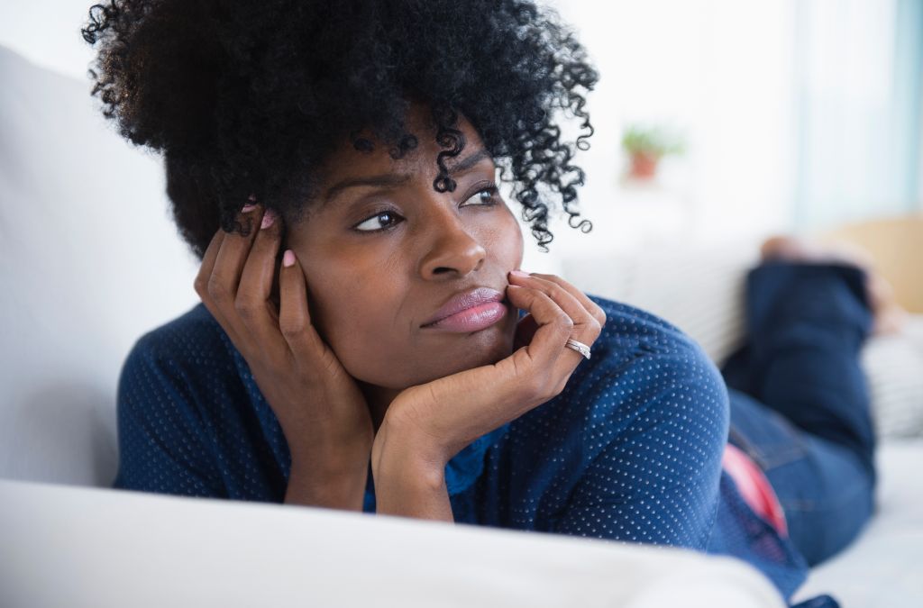 Black woman laying on sofa