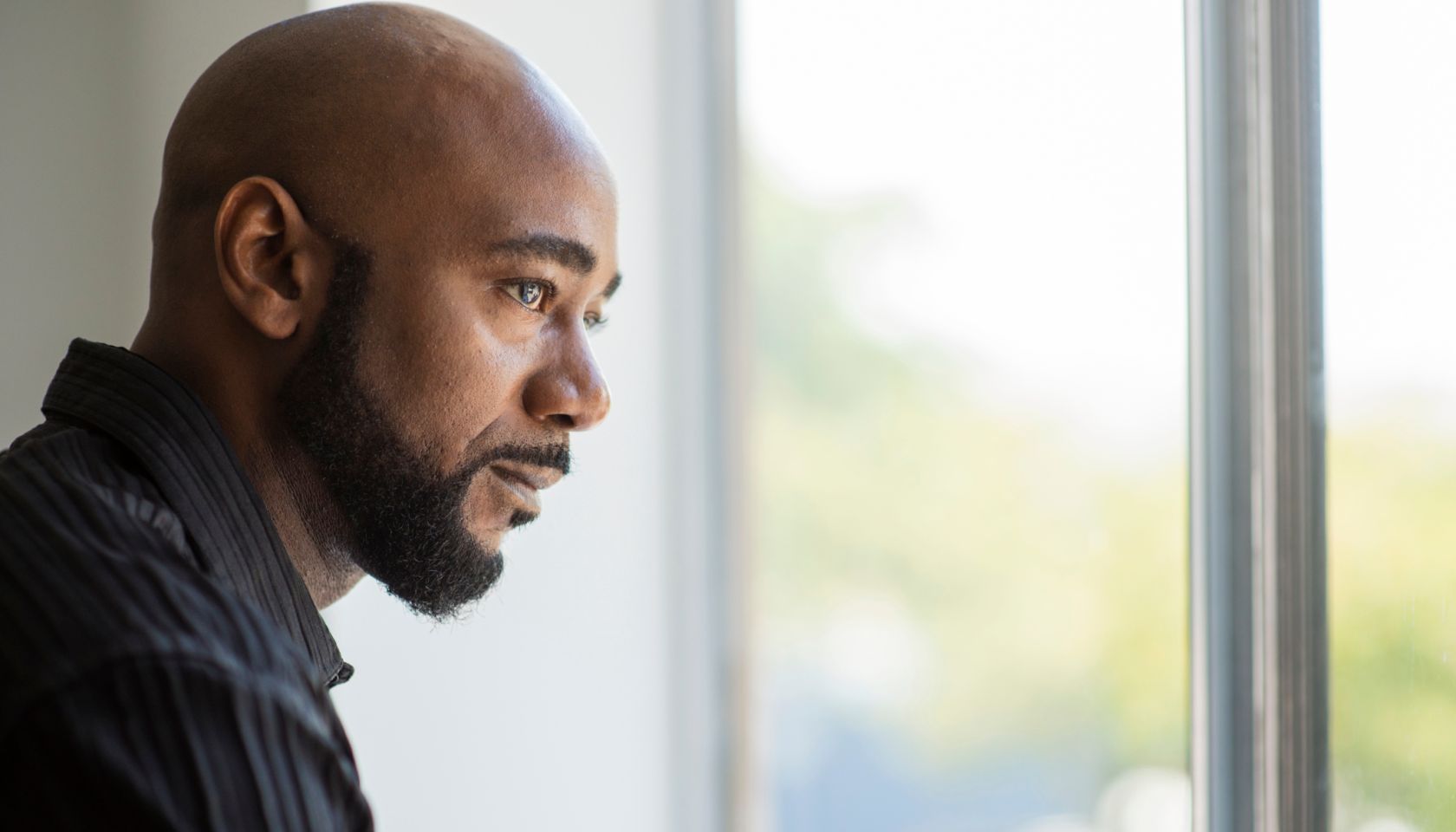 Black man looking out window