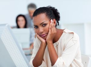 Bored young businesswoman at her desk. Business concept.