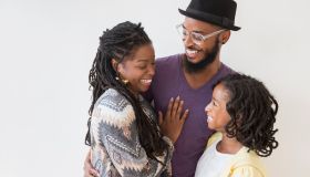 Smiling Black family hugging