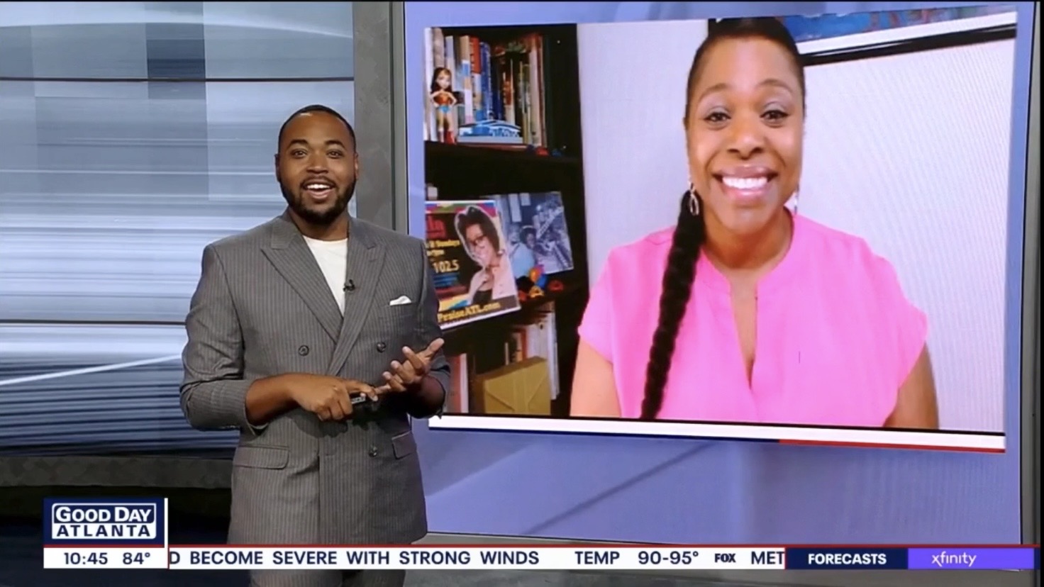 Two people, a man in a gray suit and a woman in a pink jacket, appear on a television news broadcast.